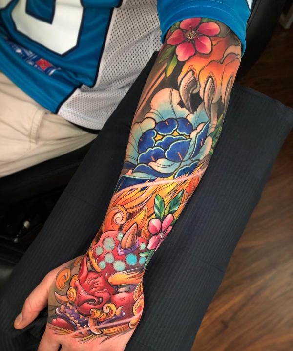 Japanese foo dog with flower hand forearm tattoo