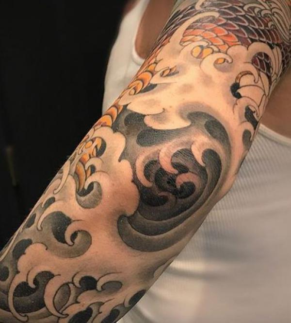 Japanese style wave tattoo on elbow
