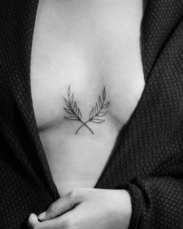 Laurel wreath line work sternum tattoo