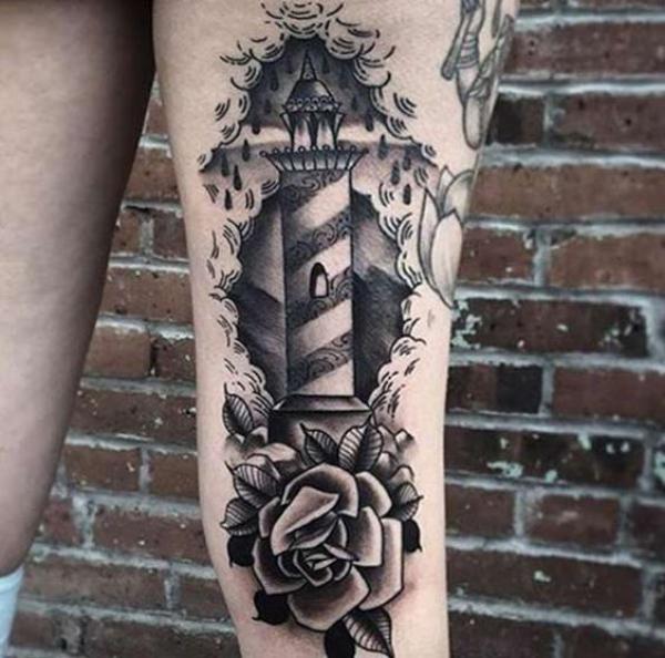 Lighthouse tattoo above knee
