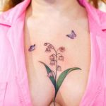 Lily of the valley with butterfly sternum tattoo