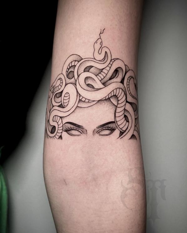 Medusa eye with snakes tattoo above elbow