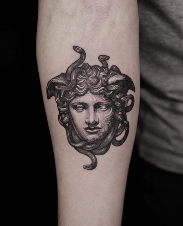Medusa tattoo below inner elbow