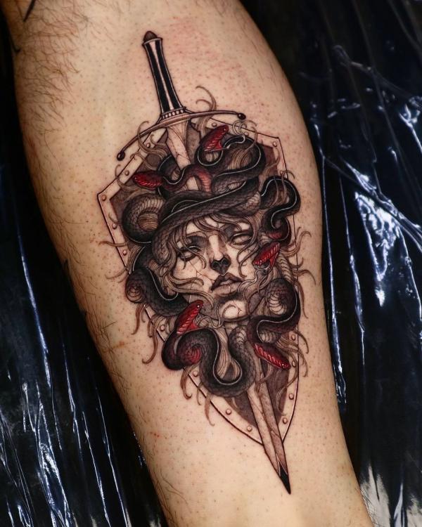 Medusa with a dagger forearm tattoo