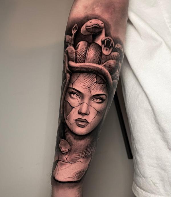Medusa with cracked face tattoo on forearm