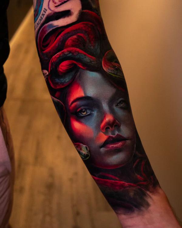Medusa with red snake forearm tattoo