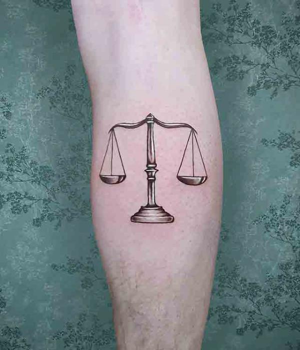 Metallic libra forearm tattoo