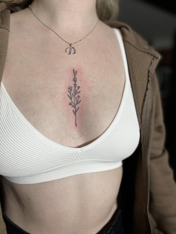 Minimalist leaves and flowers sternum tattoo