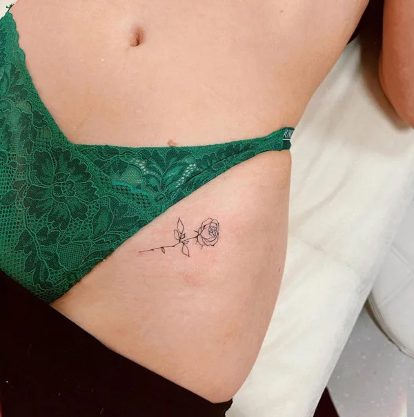 Minimalist rose bikini line tattoo