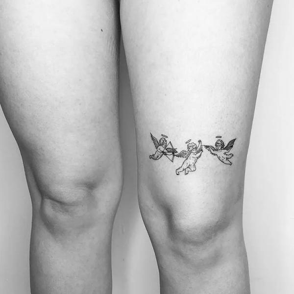 Minimalist three Cherub above knee tattoo