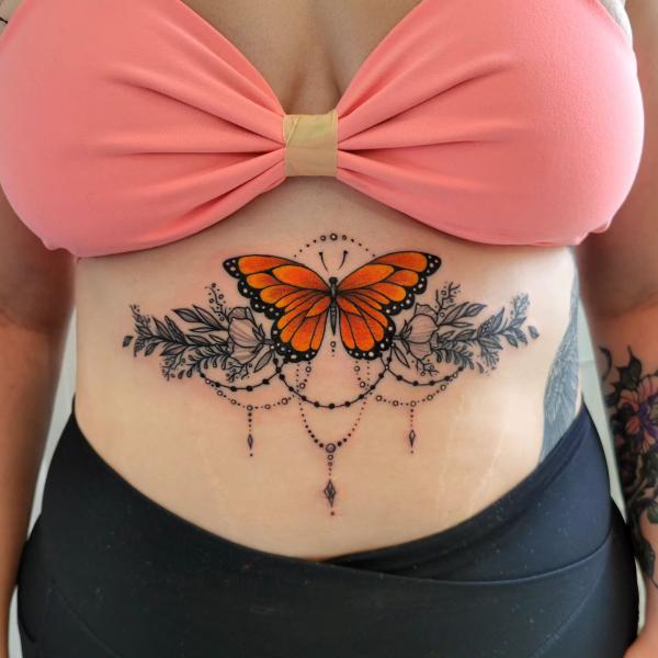 Monarch butterfly with leaves and flowers sternum tattoo