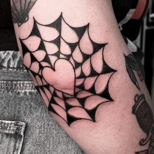 Old school black and white spiderweb with a heart symbol elbow tattoo