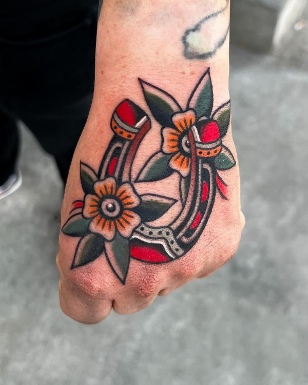 Old school horseshoe with flower hand tattoo