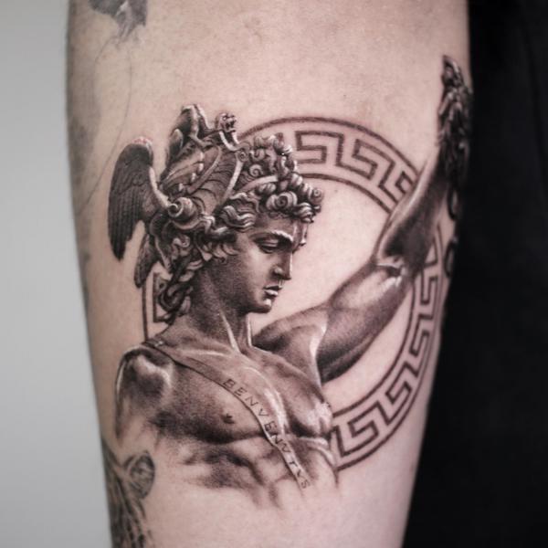 Perseus holding Medusa head against Greek key tattoo