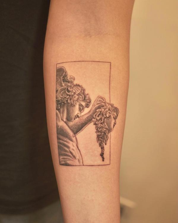 Perseus holding Medusa head tattoo on forearm