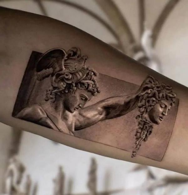 Perseus holding Medusa head upper arm tattoo