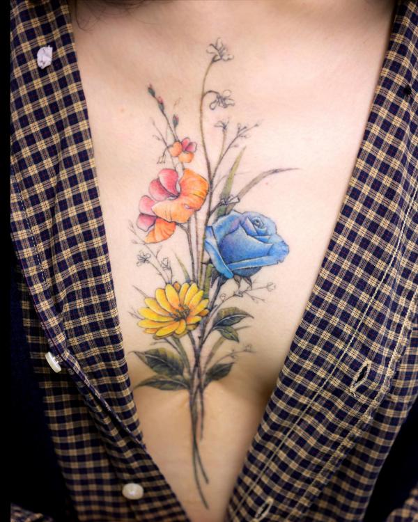 Poppy daisy and blue rose sternum tattoo