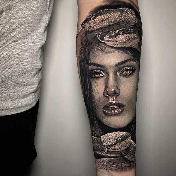 Realistic Medusa with snake tattoo on forearm