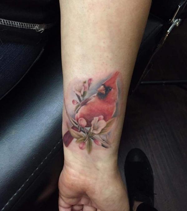 Realistic cardinal with flower wrist tattoo