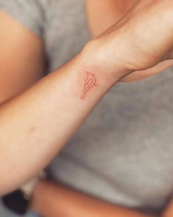 Red cardinal outline wrist tattoo