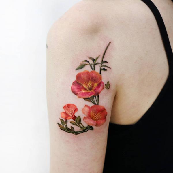 Red malva back of arm tattoo