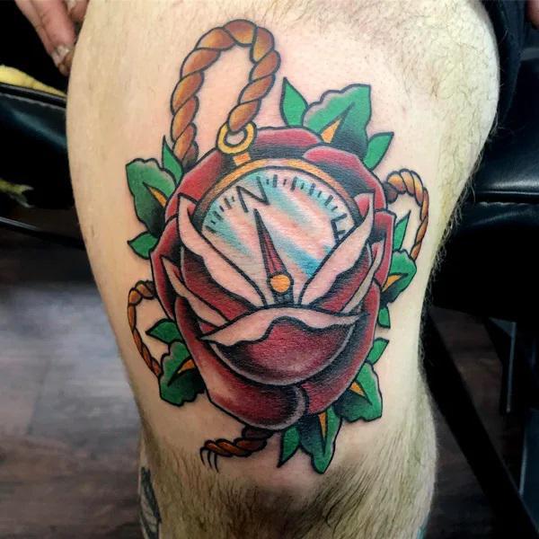 Rose compass above knee tattoo