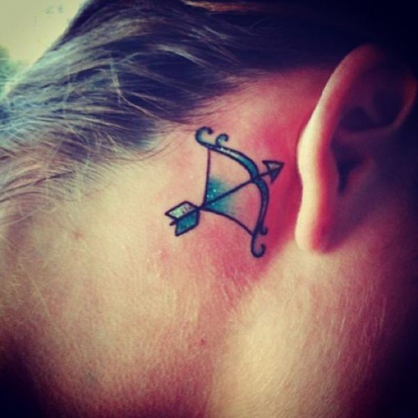 Sagittarius bow and arrow tattoo behind ear