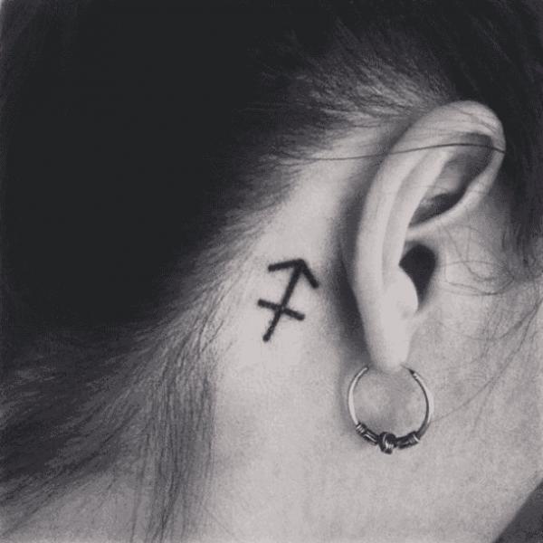 Sagittarius glyph tattoo behind ear