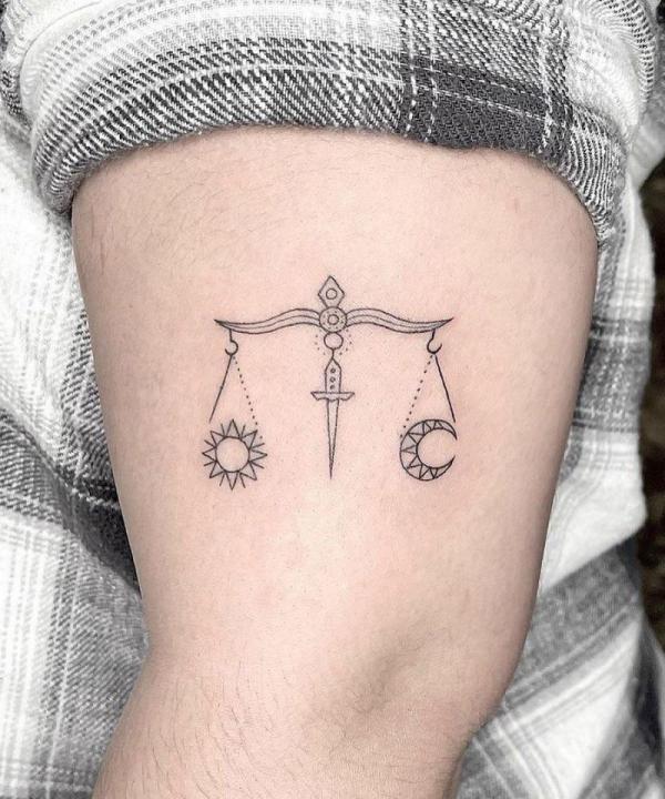 Simple sun and moon libra upper arm tattoo