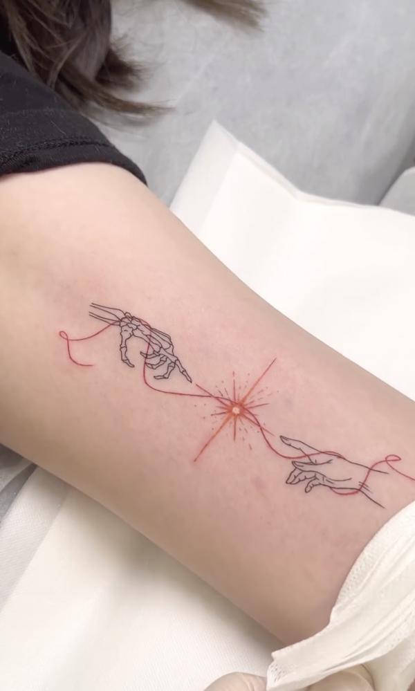 Skeleton Adam hands with sun outline tattoo