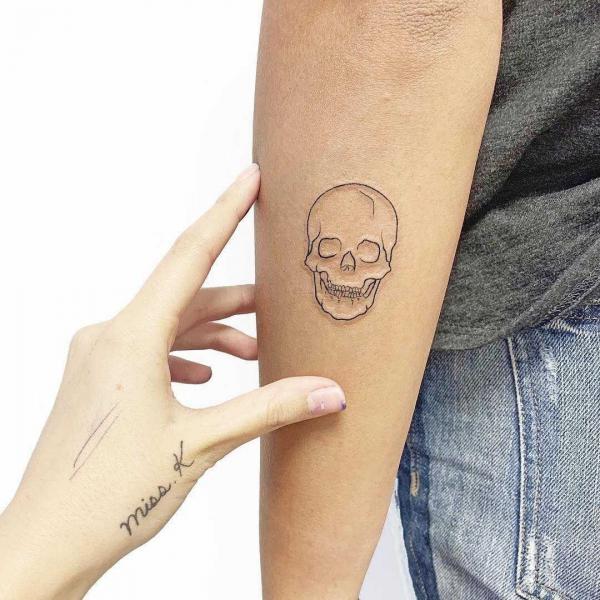 Skull outline arm tattoo
