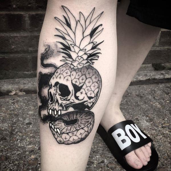 Sliced Pineapple Skull lower leg tattoo black and grey