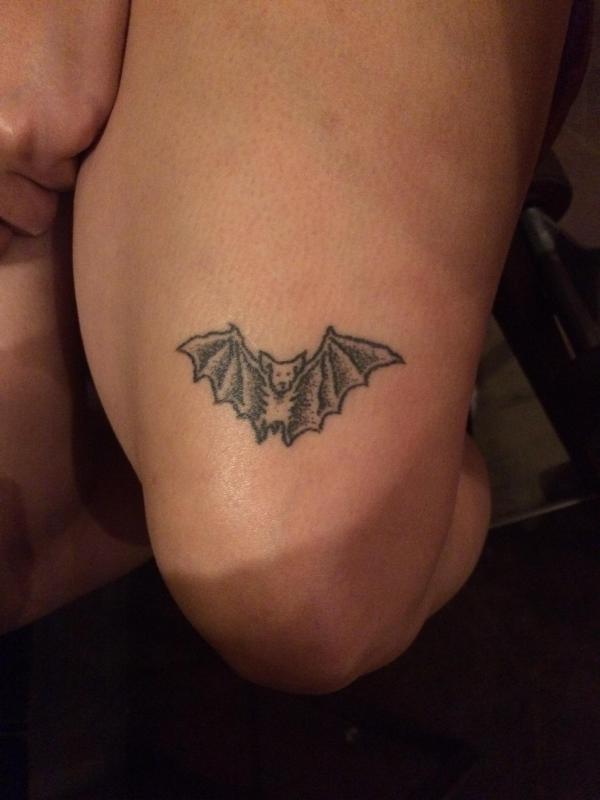 Small bat above knee tattoo