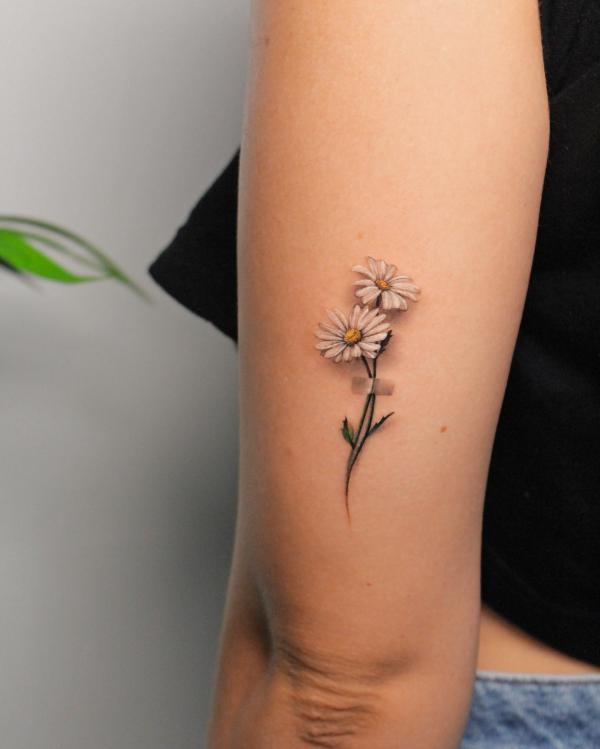 Small daisy back of arm tattoo