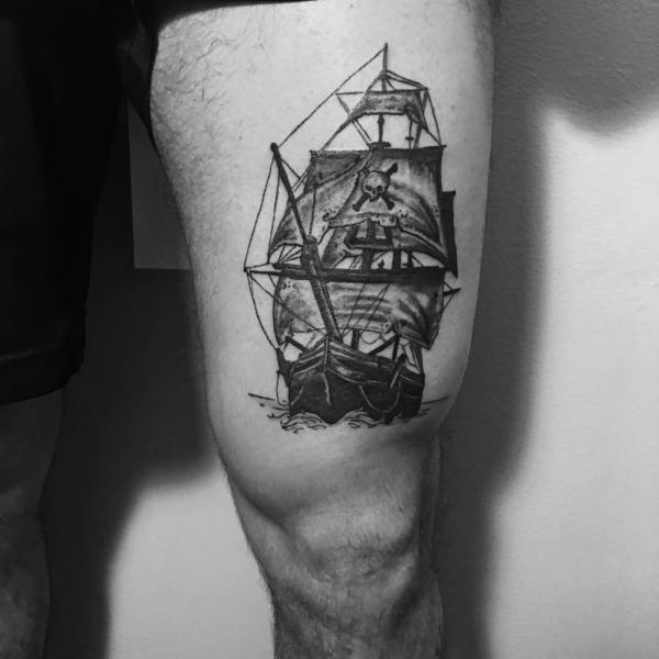 Small pirate ship above the knee tattoo