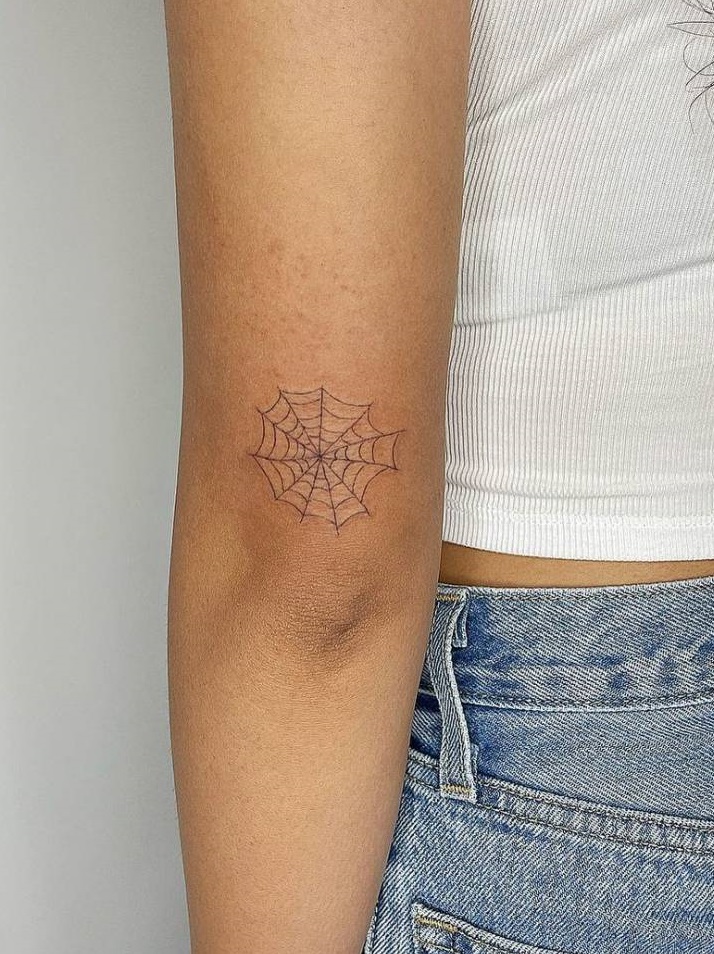 Small spider web elbow tattoo