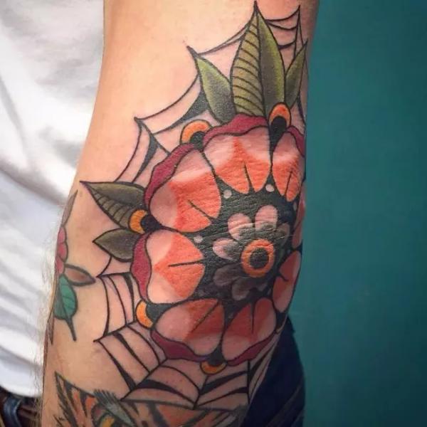 Spider web and flower elbow tattoo
