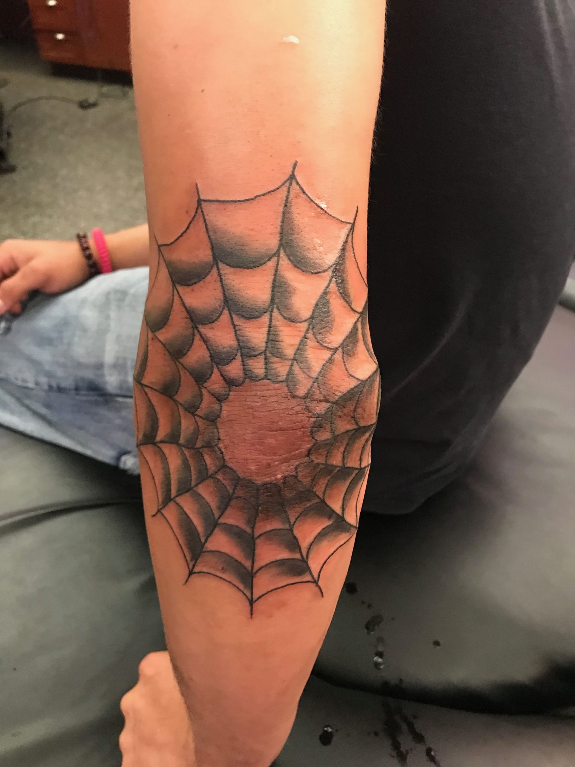 Spider web elbow tattoo with black shade scaled