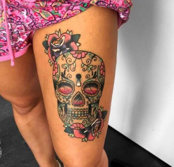 Sugar skull with rose above knee tattoo