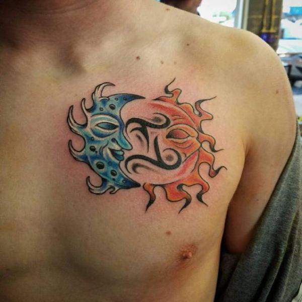 Sun and moon face with gemini glyph chest tattoo