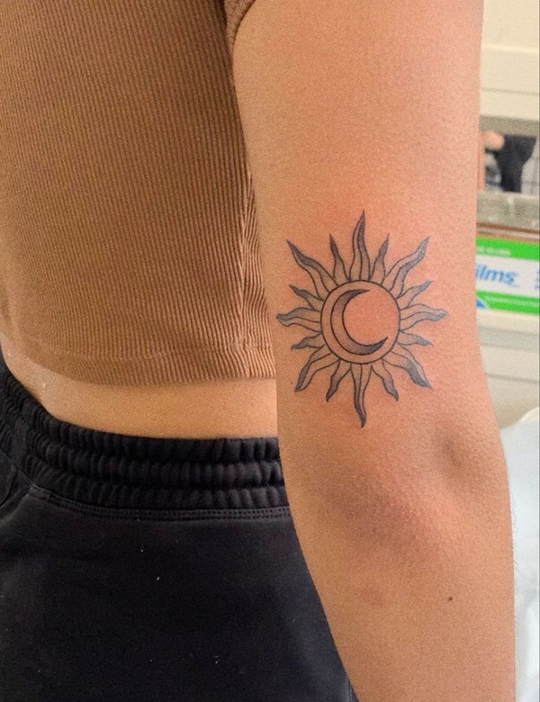 Sun and moon tattoo above elbow