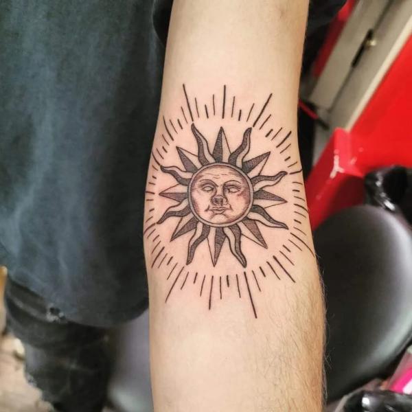 Sun face inner elbow tattoo