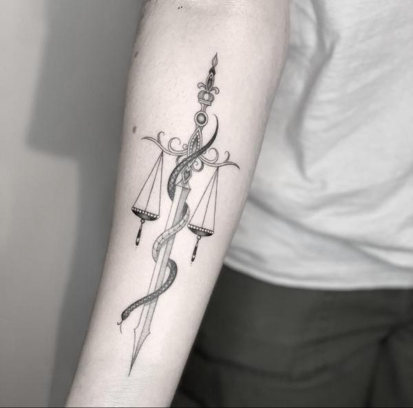 Sword libra with snake forearm tattoo