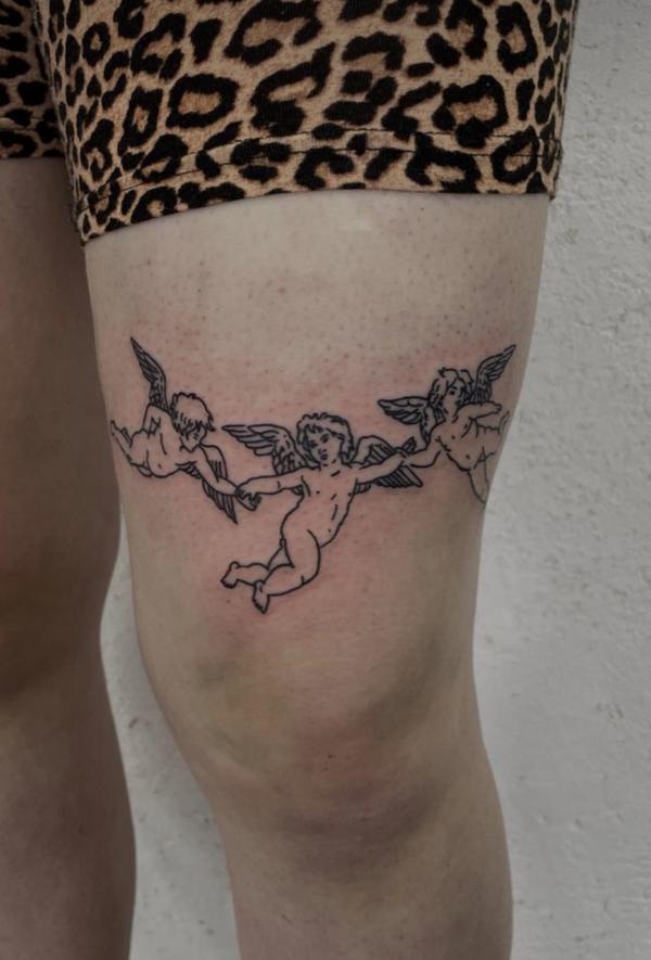 Three cherub tattoo above knee