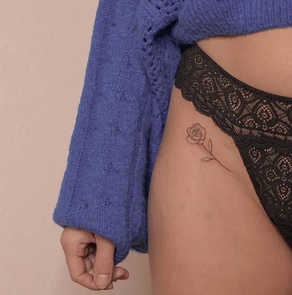 Tiny bikini line rose outline tattoo