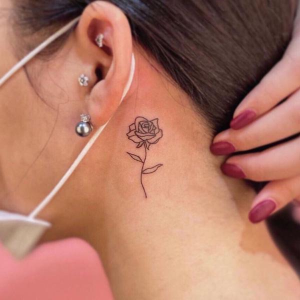 Tiny rose outline tattoo behind ear