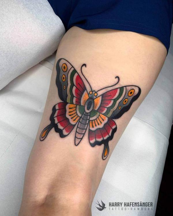 Traditional butterfly above knee tattoo
