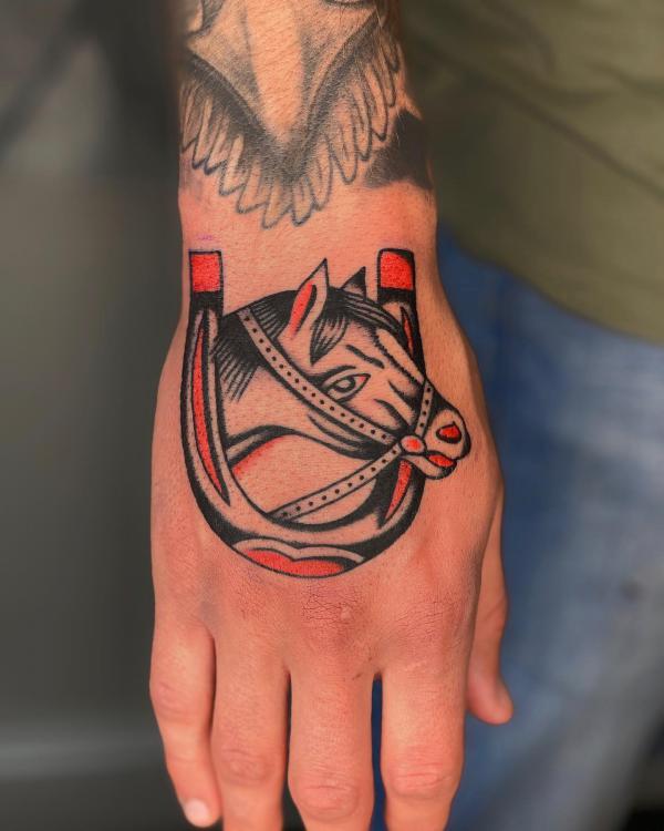 Traditional horse head with horseshoe tattoo on hand