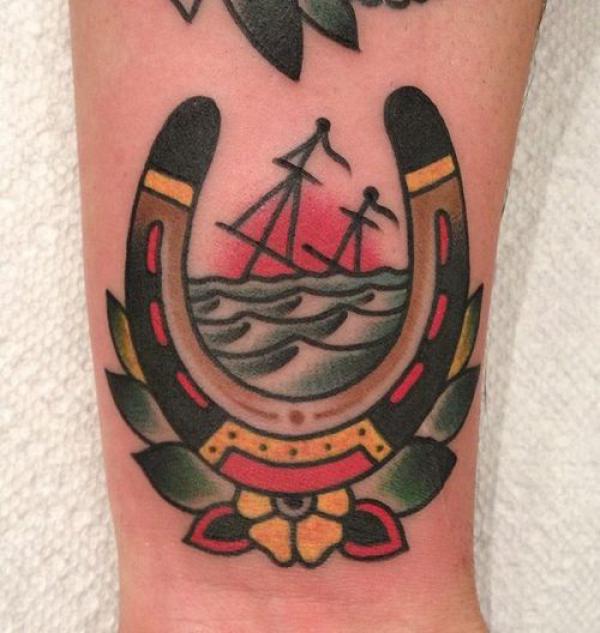 Traditional horseshoe and boat sunset tattoo