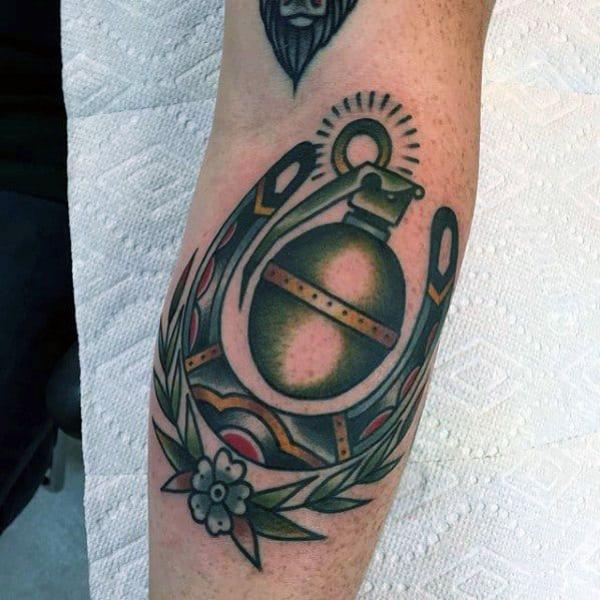 Traditional horseshoe and hand grenade forearm tattoo